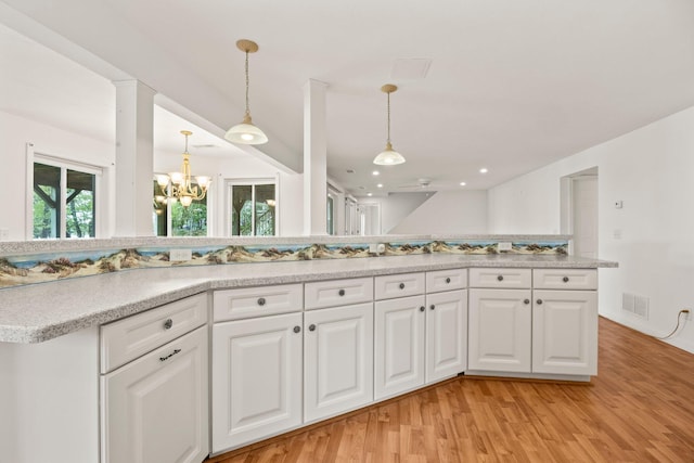 47 Cove View Dr, South Yarmouth, MA 02664 - kitchen featuring light wood-style flooring, a chandelier, light countertops, and white cabinets