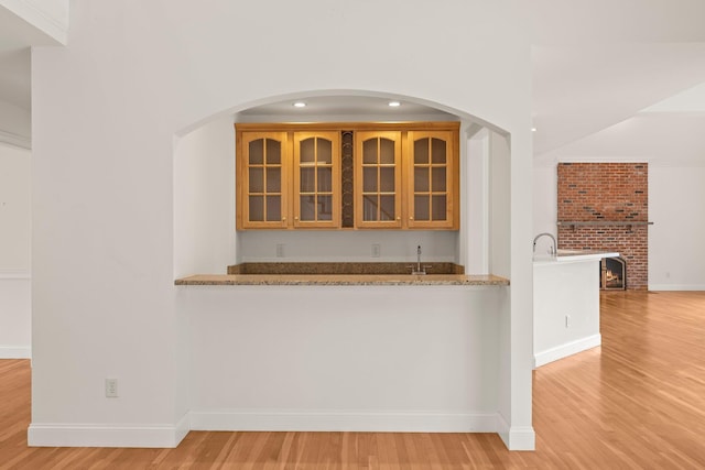 47 Cove View Dr, South Yarmouth, MA 02664 - bar area featuring light wood-type flooring, baseboards, a brick fireplace, arched walkways, and recessed lighting