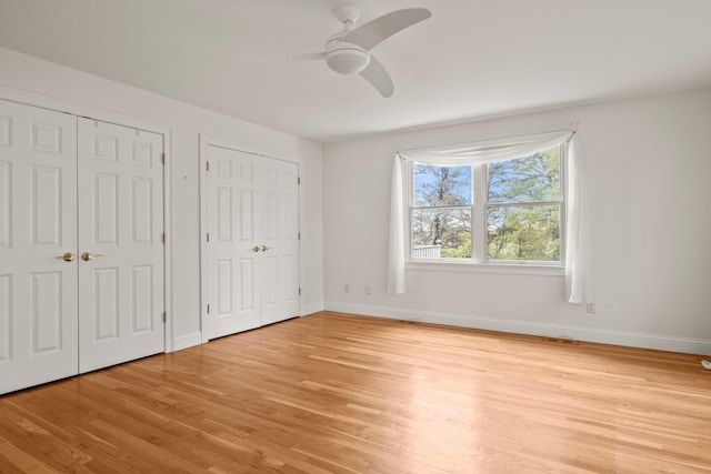47 Cove View Dr, South Yarmouth, MA 02664 - unfurnished bedroom with multiple closets, light wood finished floors, baseboards, and ceiling fan