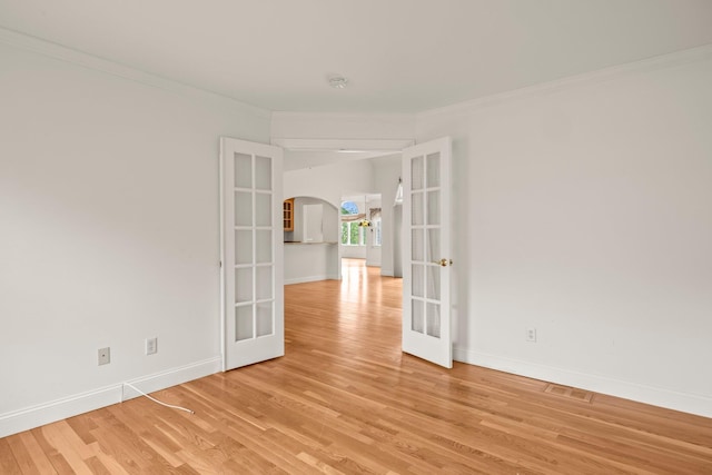 47 Cove View Dr, South Yarmouth, MA 02664 - empty room featuring french doors, arched walkways, crown molding, baseboards, and light wood-style flooring