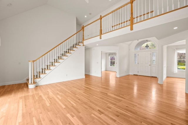 47 Cove View Dr, South Yarmouth, MA 02664 - unfurnished living room with high vaulted ceiling, wood finished floors, stairway, baseboards, and recessed lighting