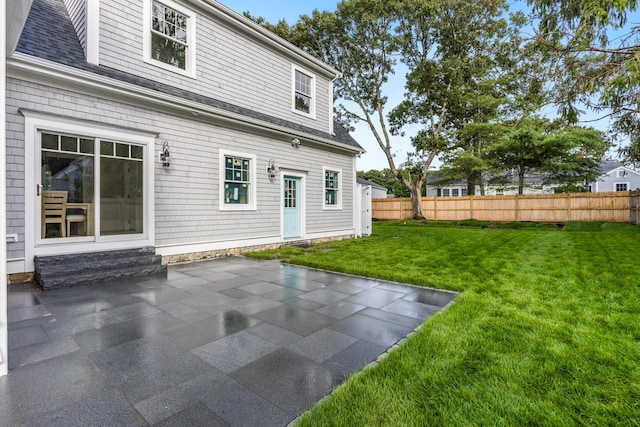 back of property featuring a patio area and a lawn