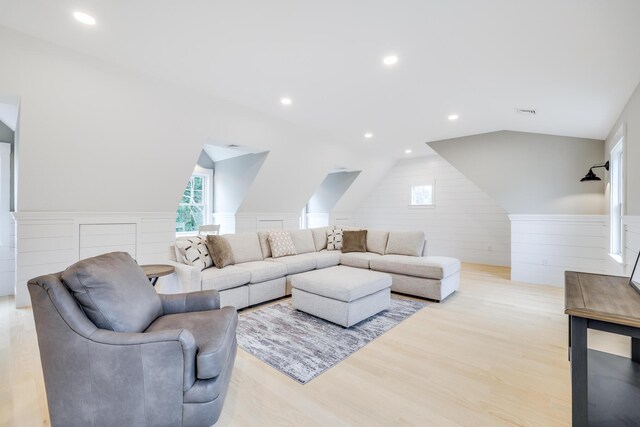 living room with light wood-type flooring and lofted ceiling