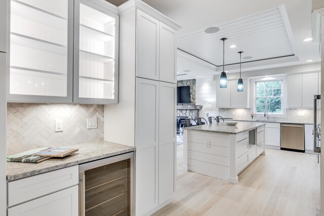 kitchen featuring dishwasher, white cabinetry, hanging light fixtures, light hardwood / wood-style flooring, and wine cooler