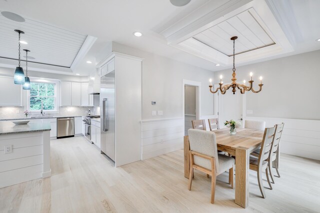 dining area featuring sink, a raised ceiling, a chandelier, wooden ceiling, and light hardwood / wood-style flooring