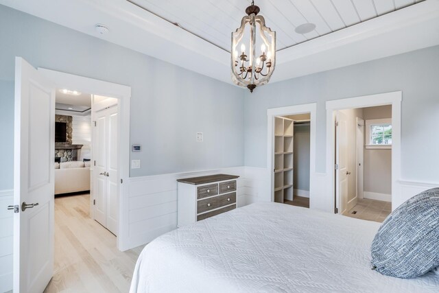 bedroom featuring an inviting chandelier, light hardwood / wood-style flooring, a closet, and a spacious closet