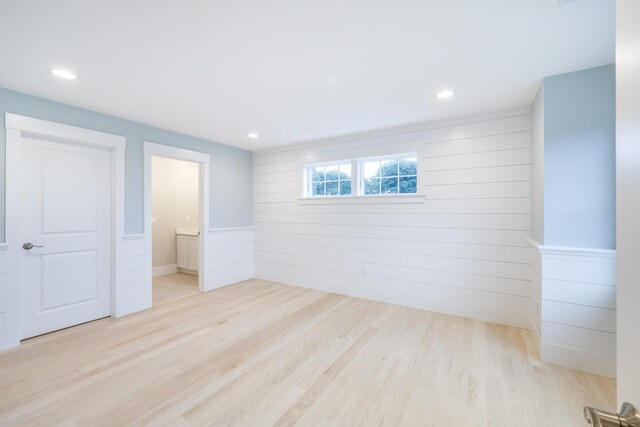 interior space with wooden walls and light hardwood / wood-style floors