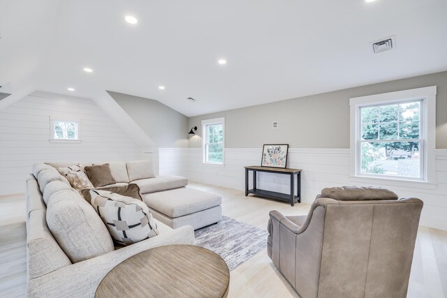 living room with light hardwood / wood-style flooring and vaulted ceiling