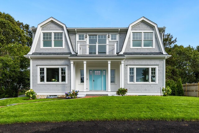 view of front of home with a balcony and a front yard