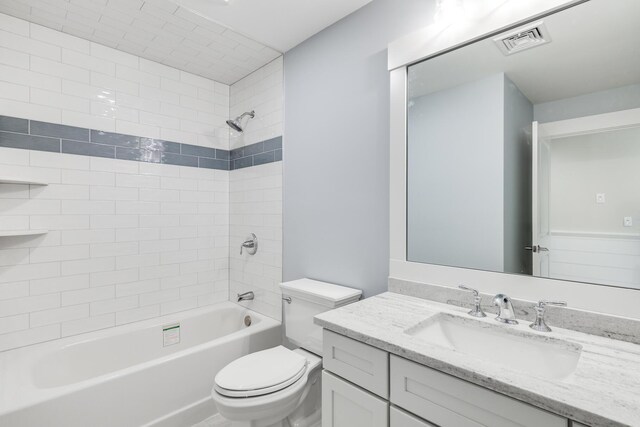 full bathroom with tiled shower / bath combo, toilet, and vanity