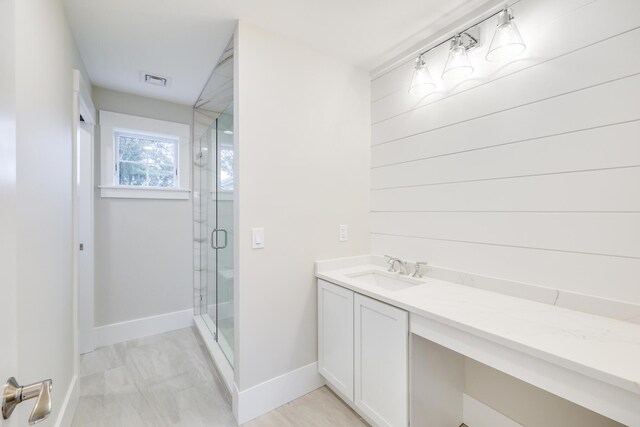 bathroom with a shower with shower door and vanity