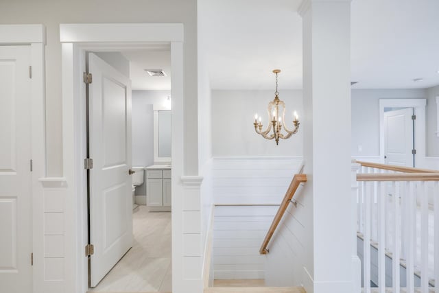 stairs featuring tile patterned floors and a chandelier