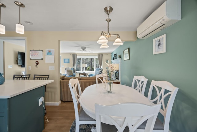 dining room featuring ceiling fan, an AC wall unit, dark wood-style flooring, and baseboards