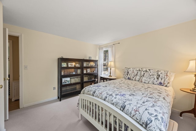 bedroom with baseboards and light colored carpet