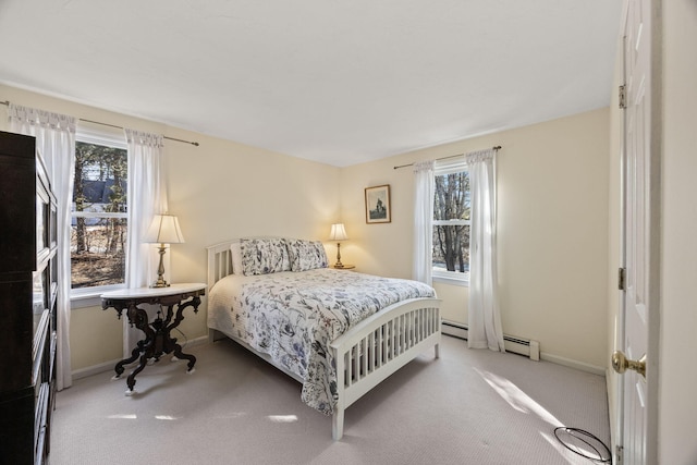 bedroom featuring light carpet, baseboard heating, and baseboards