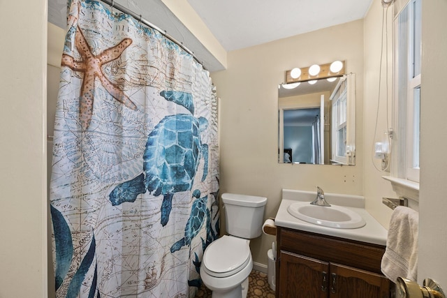 bathroom featuring toilet, vanity, and baseboards