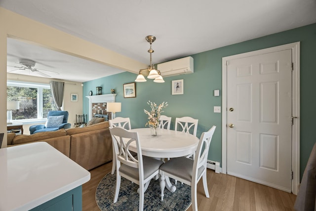 dining space featuring light wood finished floors, ceiling fan, baseboard heating, and an AC wall unit