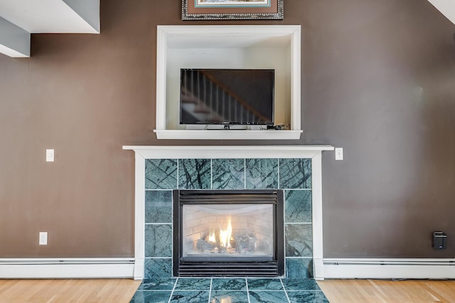 105 Edgewater Dr W, East Falmouth, MA 02536 - detailed view of a tiled fireplace, wood finished floors, a baseboard heating unit, and a baseboard radiator
