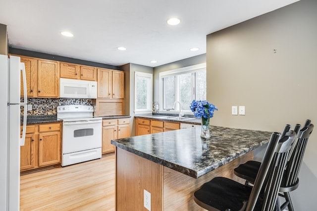 105 Edgewater Dr W, East Falmouth, MA 02536 - kitchen featuring white appliances, a peninsula, a sink, dark countertops, and decorative backsplash