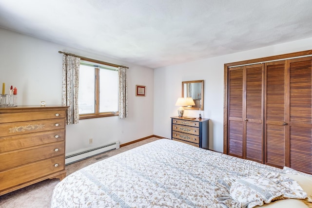 bedroom featuring a baseboard heating unit, carpet, a closet, and baseboards