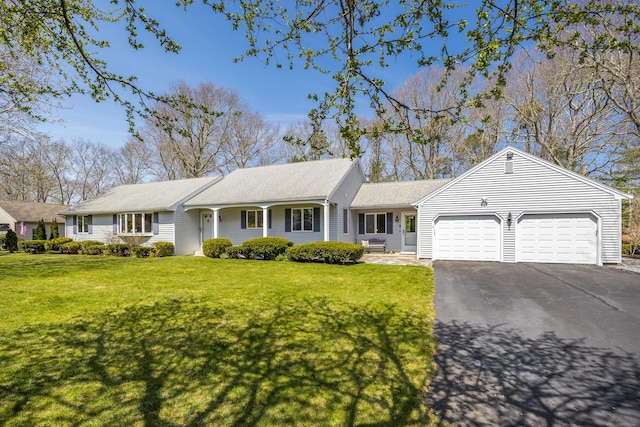 ranch-style home featuring an attached garage, asphalt driveway, and a front lawn
