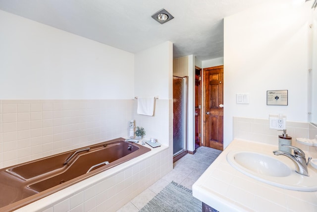 full bathroom with a jetted tub, a stall shower, tile patterned floors, and vanity