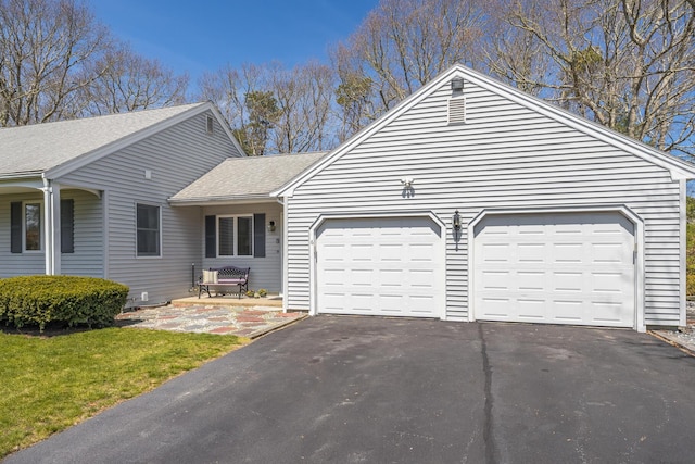 ranch-style house featuring driveway, a shingled roof, and an attached garage