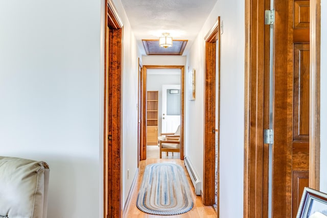 hall featuring a baseboard radiator and light wood-type flooring