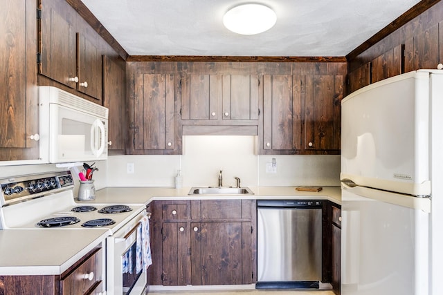 kitchen featuring white appliances, a sink, light countertops, and dark brown cabinetry