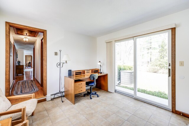 home office featuring healthy amount of natural light, light tile patterned flooring, a baseboard heating unit, and baseboards