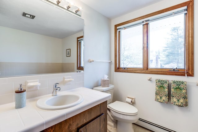 bathroom with a baseboard radiator, toilet, vanity, and backsplash