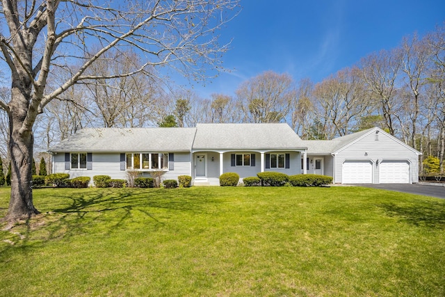 ranch-style home featuring a garage, driveway, a front lawn, and roof with shingles
