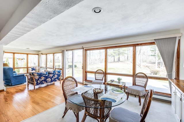 dining area featuring a baseboard radiator and light wood-type flooring