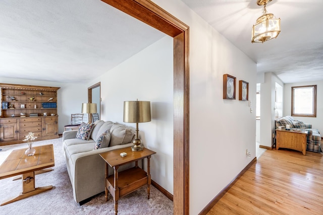 living area featuring light wood-style floors and baseboards