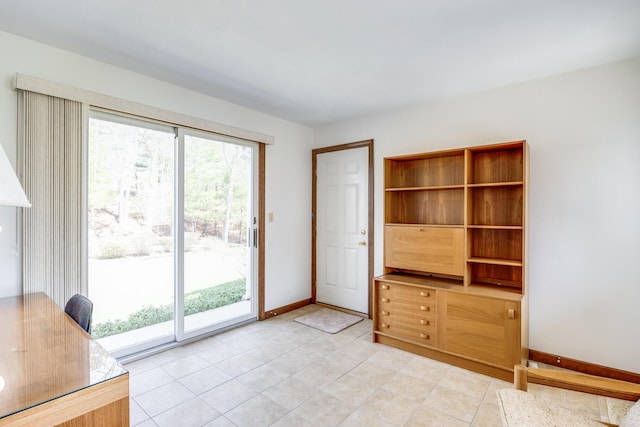 doorway with baseboards and light tile patterned floors