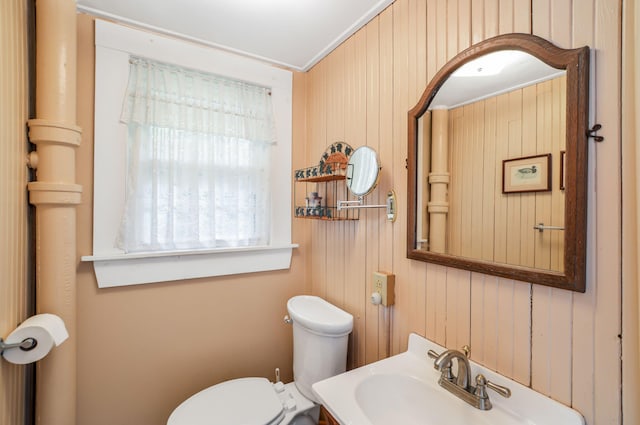 61 Bay Rd, North Falmouth, MA 02556 - bathroom with toilet, wood walls, a sink, and crown molding