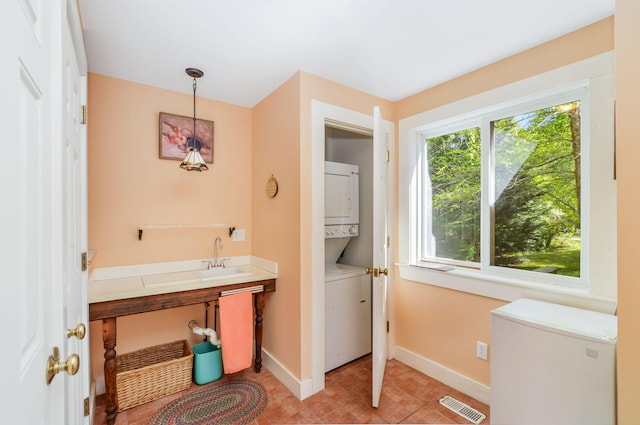 61 Bay Rd, North Falmouth, MA 02556 - bathroom featuring stacked washing machine and dryer, baseboards, tile patterned flooring, and a sink