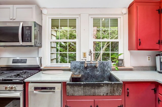 61 Bay Rd, North Falmouth, MA 02556 - kitchen with stainless steel appliances, red cabinetry, and light countertops