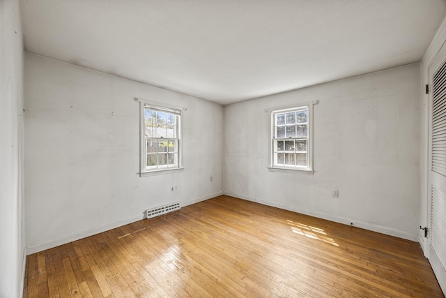 spare room with plenty of natural light, hardwood / wood-style floors, and baseboards