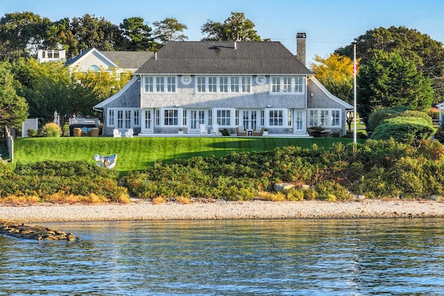 rear view of house with a water view, a yard, and french doors