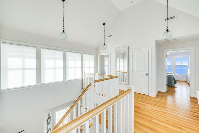 hallway featuring hardwood / wood-style flooring and high vaulted ceiling