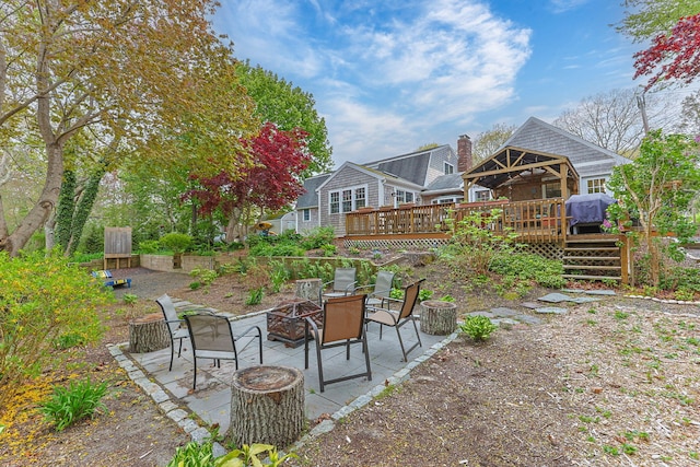 view of yard with an outdoor fire pit, a deck, and a patio