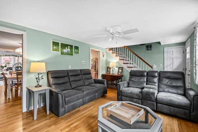 living room featuring a ceiling fan, stairway, and wood finished floors