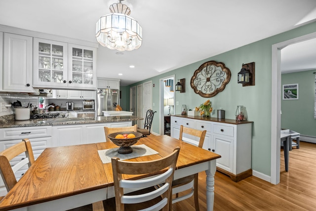 dining area with light wood-style flooring, recessed lighting, baseboards, and a chandelier