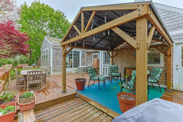 wooden deck featuring a gazebo and outdoor dining area