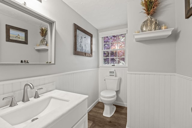 114 Stoney Cliff Rd, Centerville, MA 02632 - bathroom with wood finished floors, toilet, wainscoting, and vanity