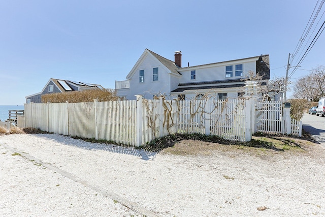 561 Commercial St, Provincetown, MA 02657 - rear view of house with a chimney and a fenced front yard