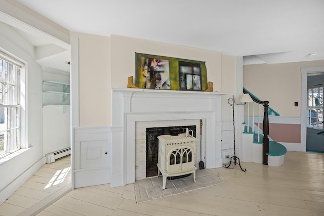 561 Commercial St, Provincetown, MA 02657 - unfurnished living room featuring a wealth of natural light, stairs, a baseboard heating unit, and wood finished floors