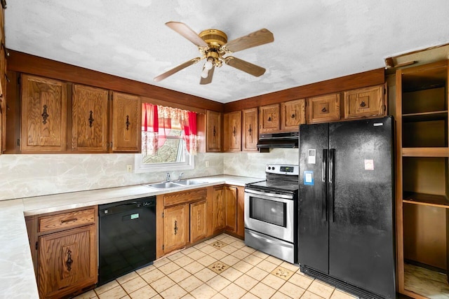 kitchen featuring black appliances, under cabinet range hood, brown cabinetry, and a sink