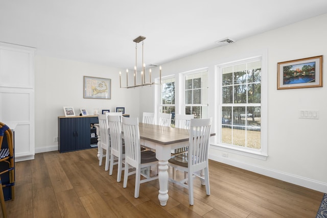 dining room with visible vents, a healthy amount of sunlight, baseboards, and wood finished floors